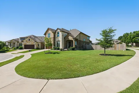 a view of a house with a big yard plants and large trees
