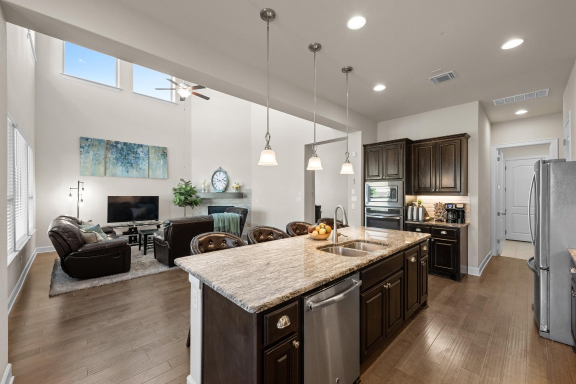 143 Pink Granite Boulevard Dripping Springs, TX 78620 - Photo 12 of 35 a large kitchen with sink a refrigerator and chairs