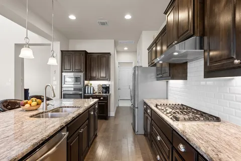 a kitchen with stainless steel appliances granite countertop a sink stove and refrigerator