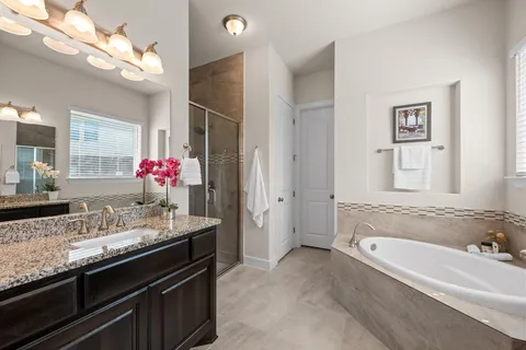 a bathroom with a granite countertop sink a large mirror and shower