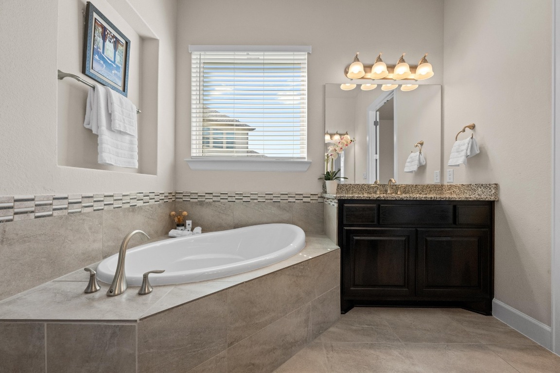 143 Pink Granite Boulevard Dripping Springs, TX 78620 - Photo 16 of 35 a bathroom with a sink and a mirror