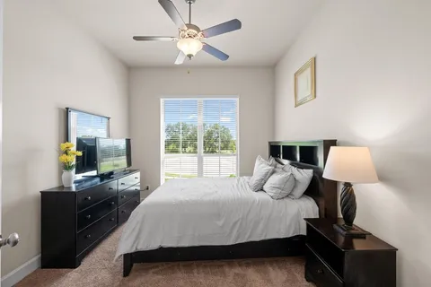 a bedroom with a bed and a flat tv screen on the dresser