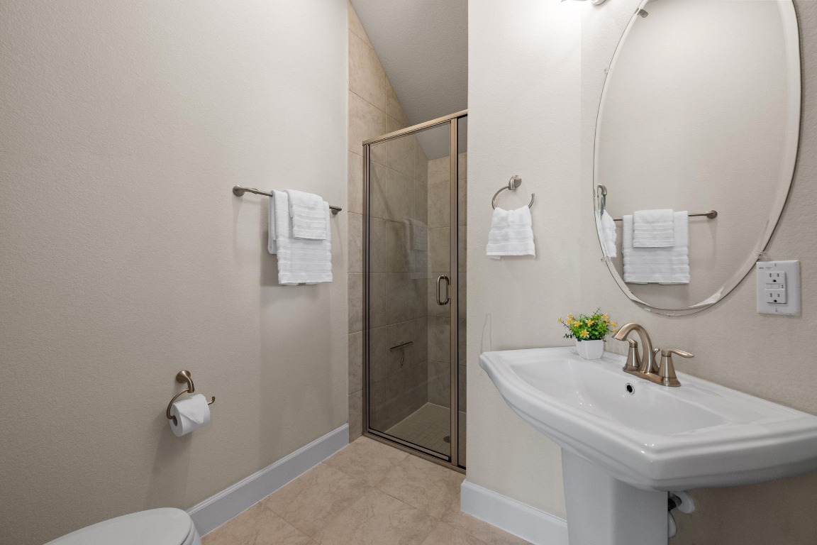 143 Pink Granite Boulevard Dripping Springs, TX 78620 - Photo 18 of 35 a bathroom with a sink and a mirror