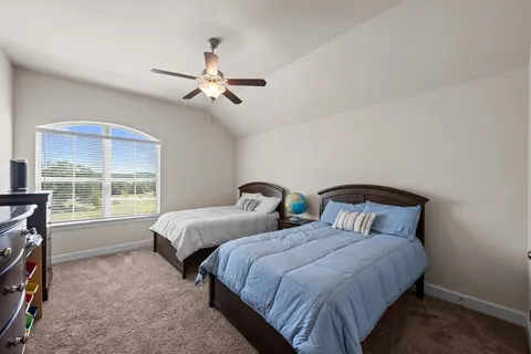 a bedroom with two beds and a window