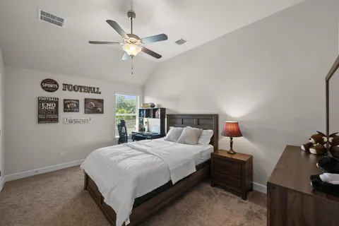 a bedroom with a bed and a dresser with the potted plant