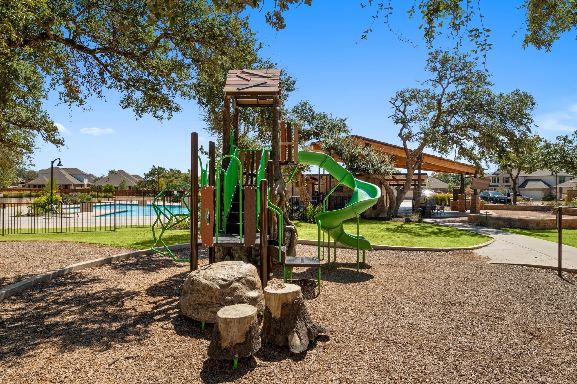 143 Pink Granite Boulevard Dripping Springs, TX 78620 - Photo 33 of 35 a view of a park with swings and slides