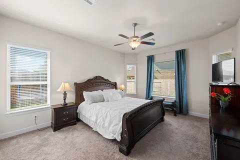 a bedroom with a bed a ceiling fan and a window