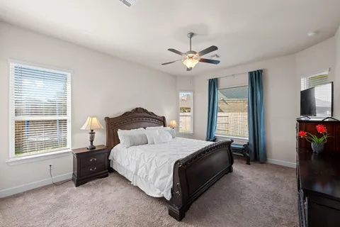 a bedroom with a bed a ceiling fan and a window