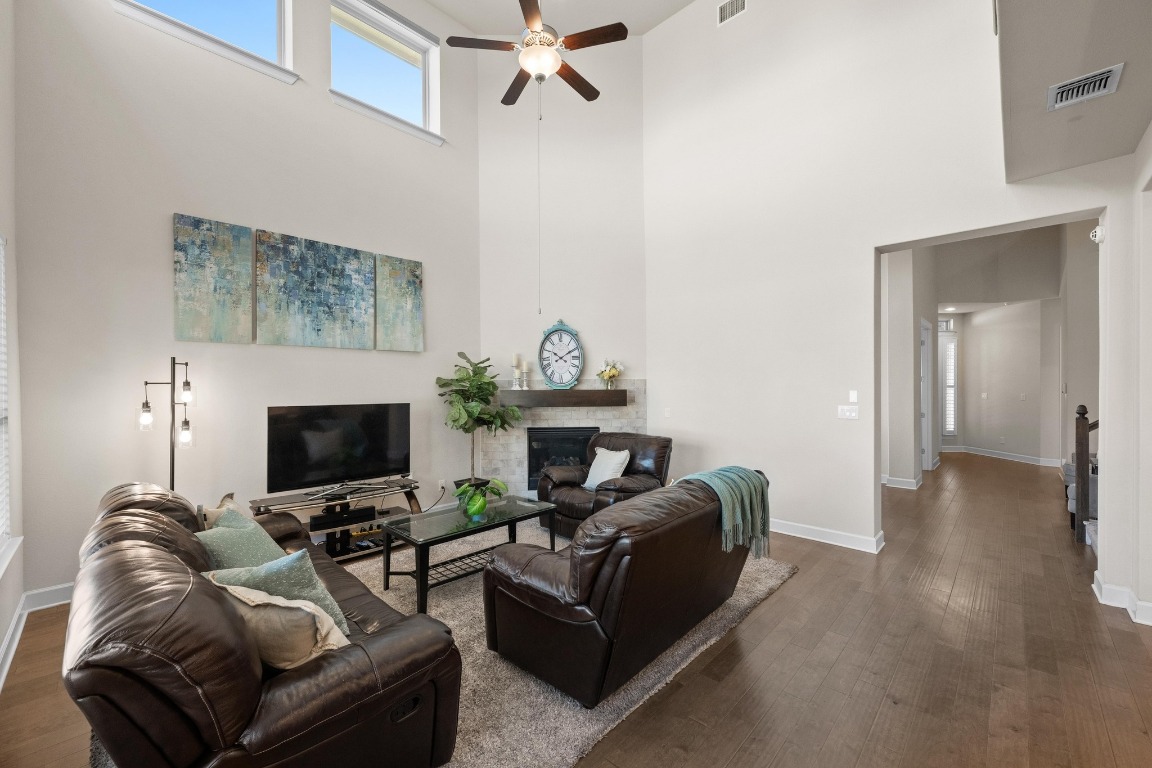 143 Pink Granite Boulevard Dripping Springs, TX 78620 - Photo 9 of 35 a living room with furniture a fireplace and a chandelier