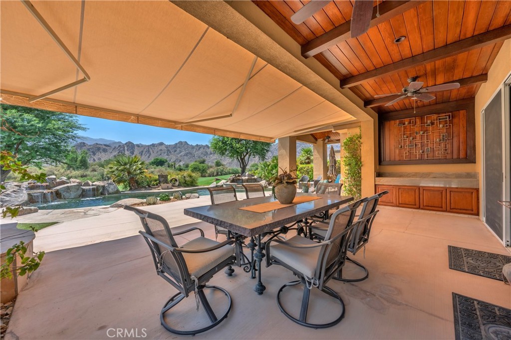 57205 Merion La Quinta, CA 92253 - Photo 45 of 55 a view of a patio with table and chairs with wooden floor and fence
