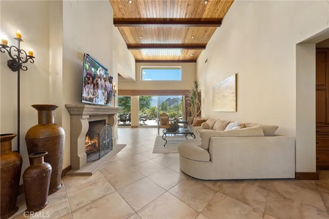 a living room with furniture a fireplace and a floor to ceiling window