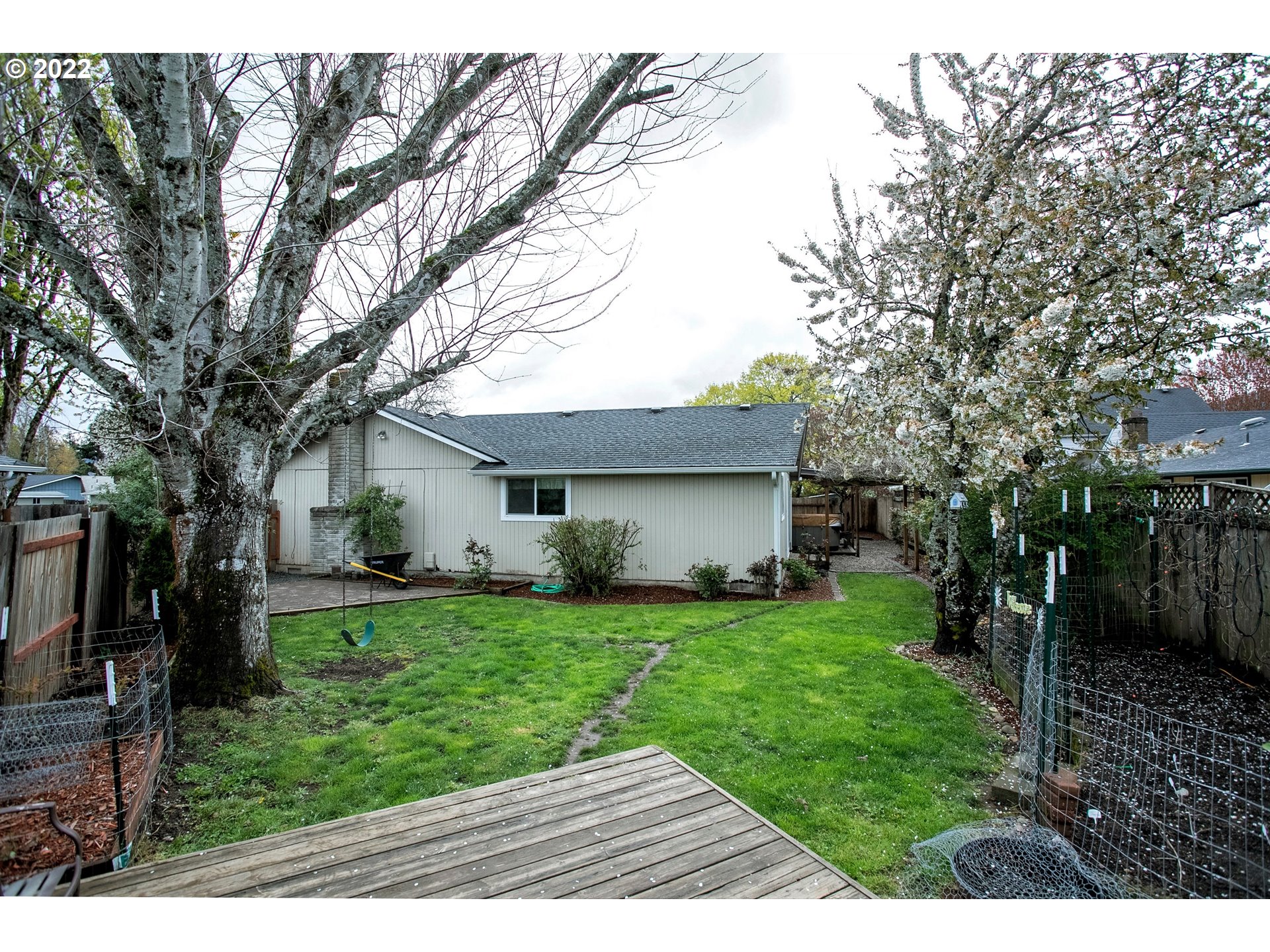 6305 C Street Springfield, OR 97478 - Photo 30 of 32 a backyard of a house with potted plants and large trees