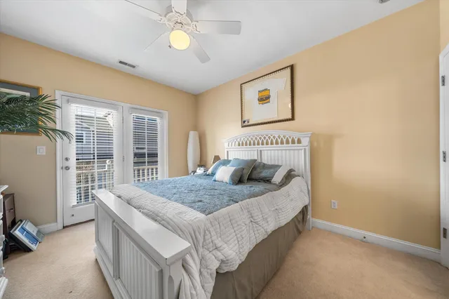 a bedroom with a bed and a large window with the view of balcony