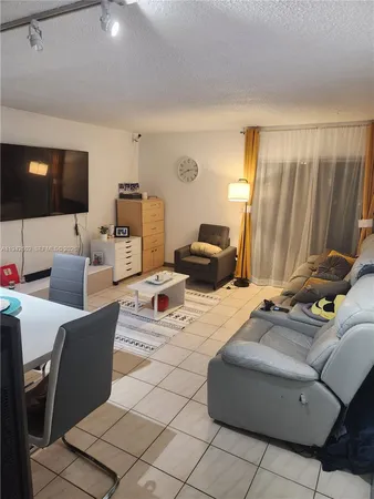 a living room with furniture a flat screen tv and a window