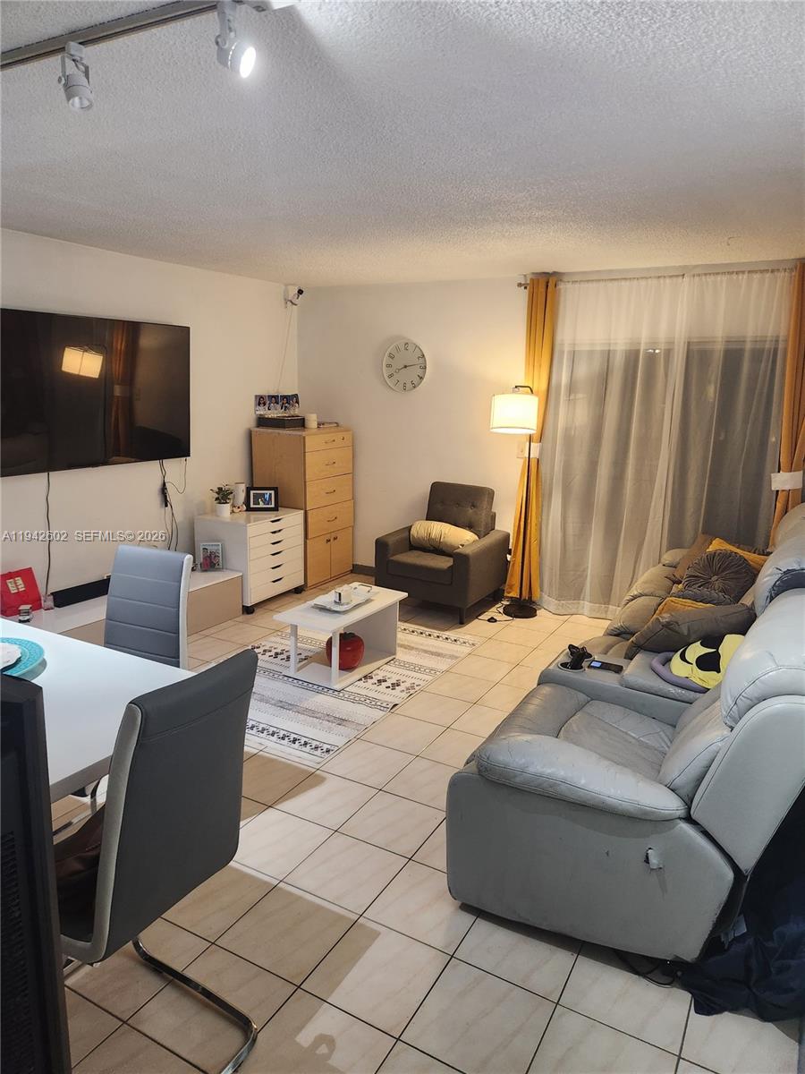 2498 Southwest 17th Avenue, Unit 4209 Miami, FL 33133 - Photo 2 of 7 a living room with furniture a flat screen tv and a window