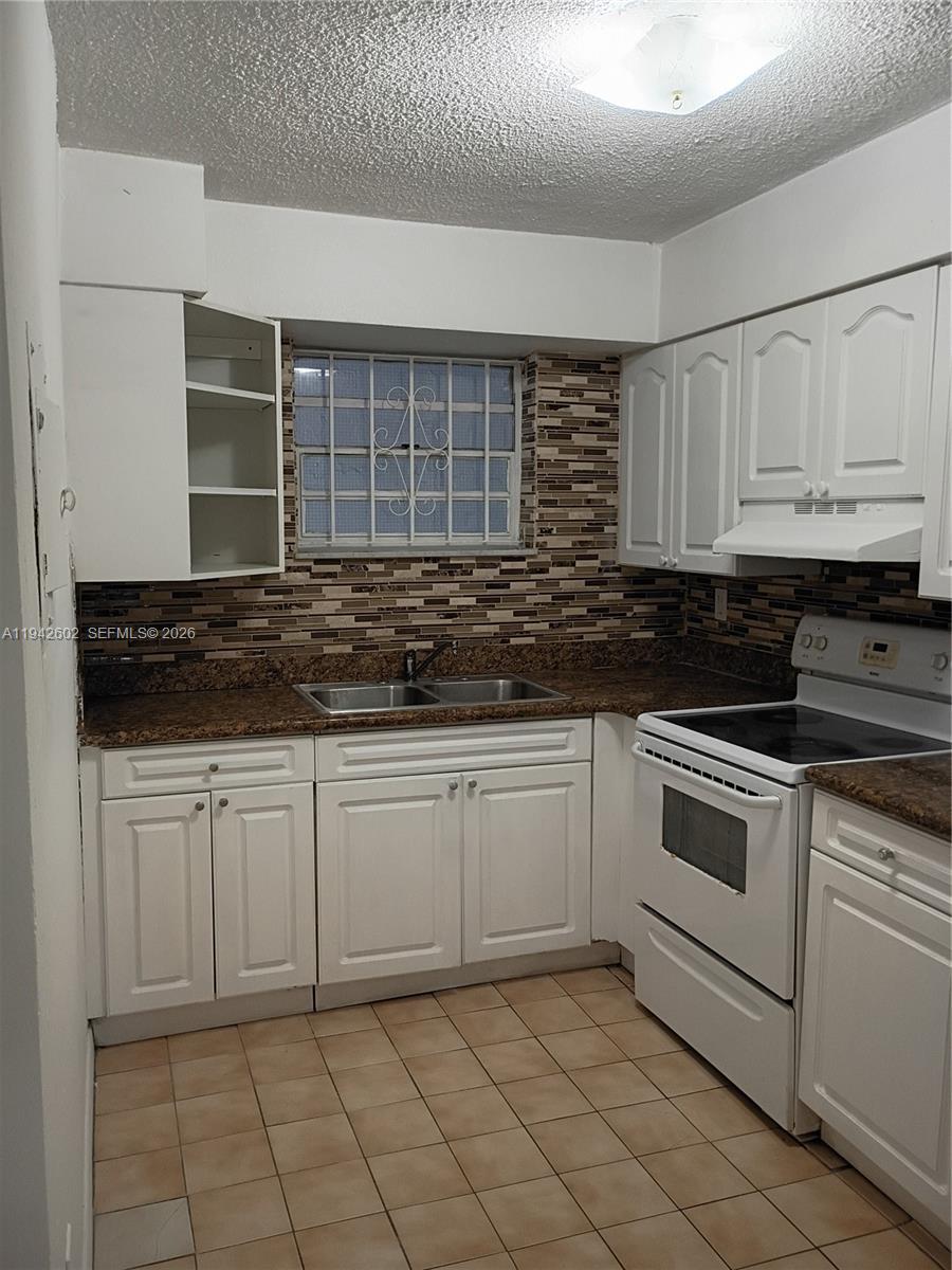 2498 Southwest 17th Avenue, Unit 4209 Miami, FL 33133 - Photo 10 of 15 a kitchen with granite countertop white cabinets and stainless steel appliances