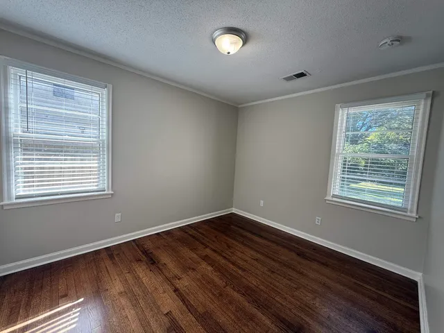 an empty room with wooden floor and a fireplace
