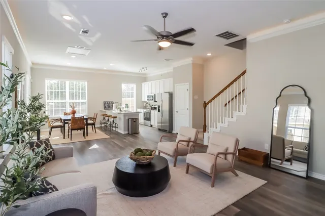 a living room with furniture potted plant and a large window