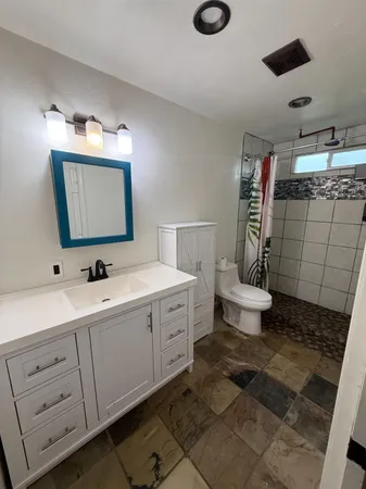 a bathroom with a toilet sink and mirror