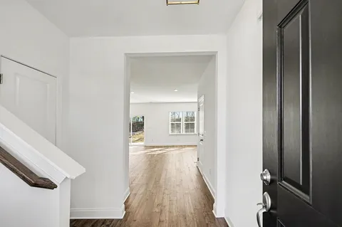 a view of a hallway with wooden floor and staircase