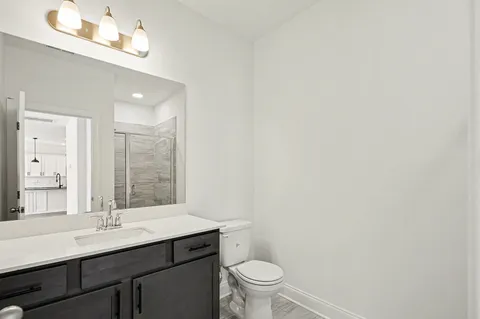 a bathroom with a sink a toilet a mirror and vanity