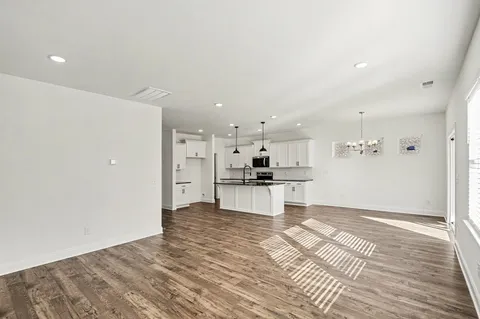 a kitchen with stainless steel appliances kitchen island granite countertop a refrigerator and a stove top oven