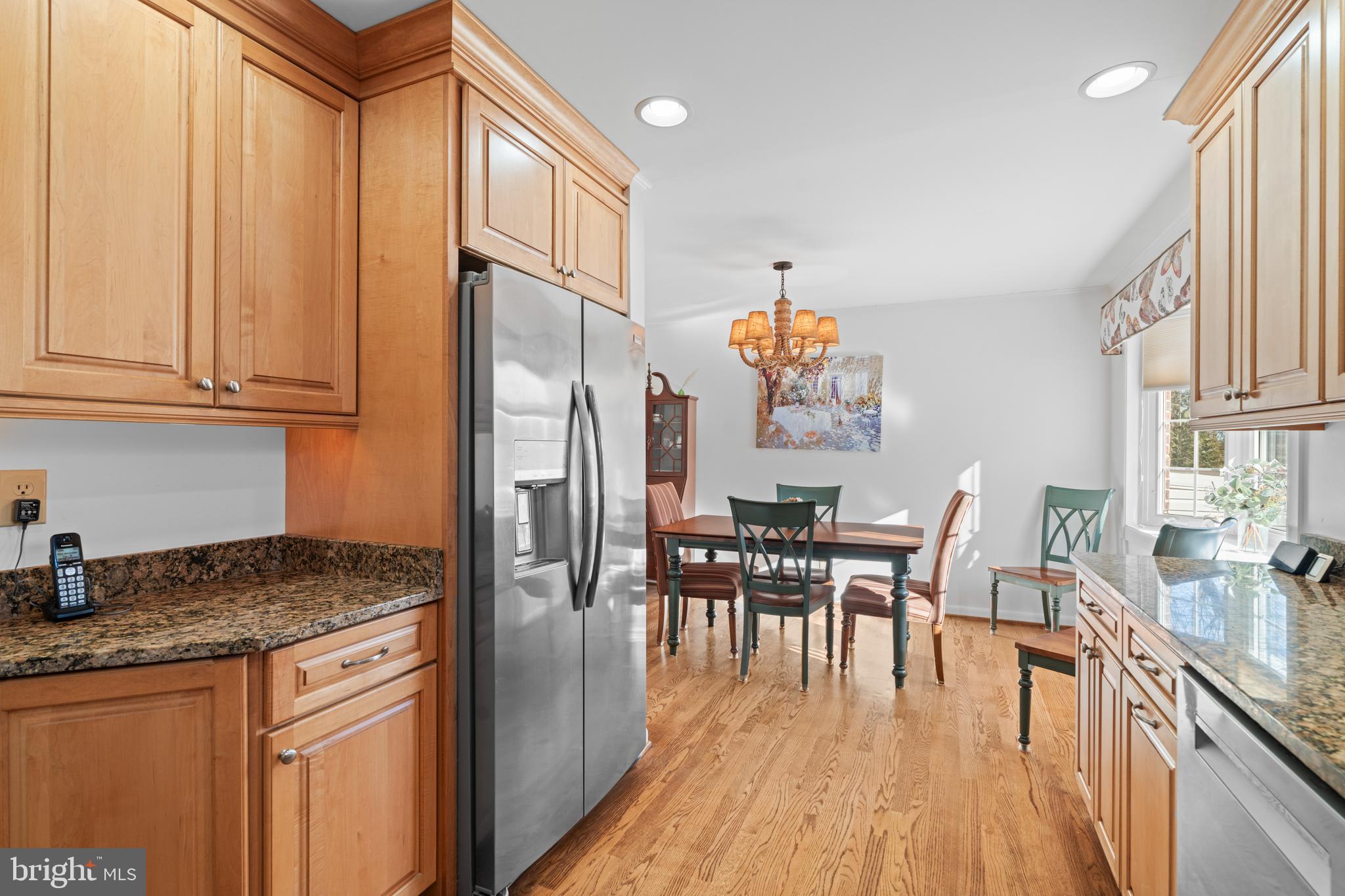 128 North Lynbrook Road Bel Air, MD 21014 - Photo 7 of 48 a kitchen with granite countertop a refrigerator a stove a dining table and chairs with wooden floor