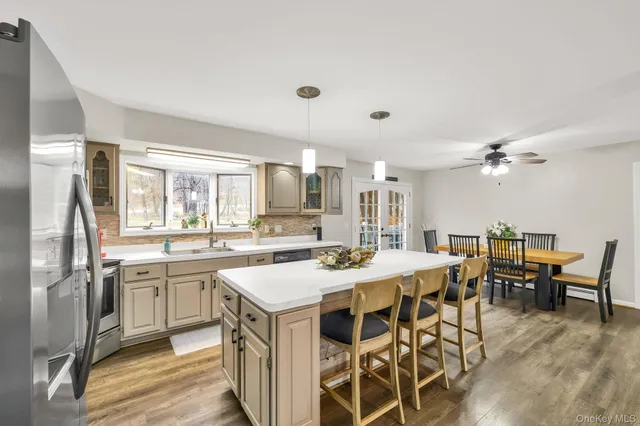 a kitchen with a sink a stove cabinets and wooden floor