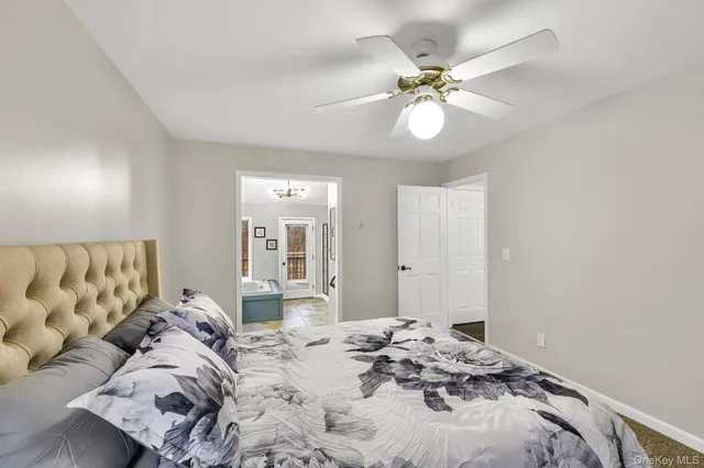 a bedroom with a bed and a ceiling fan