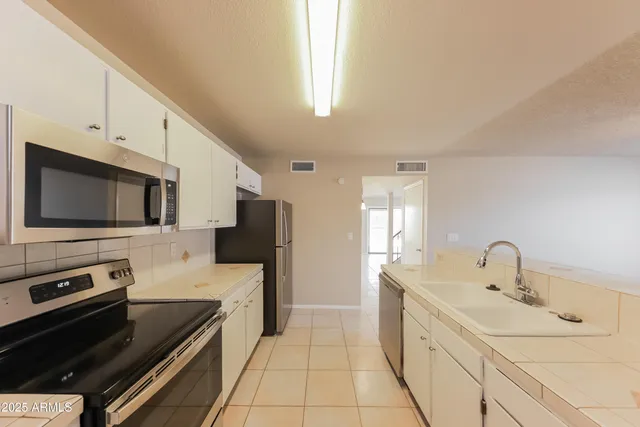 a kitchen with a sink stainless steel appliances and cabinets