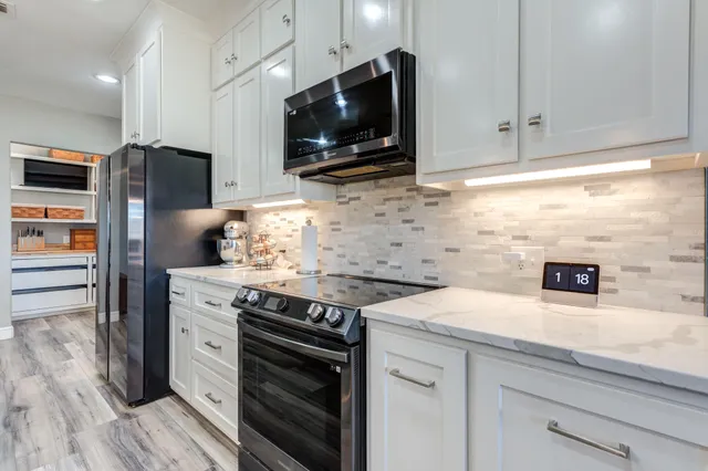 a kitchen with stainless steel appliances a stove and cabinets