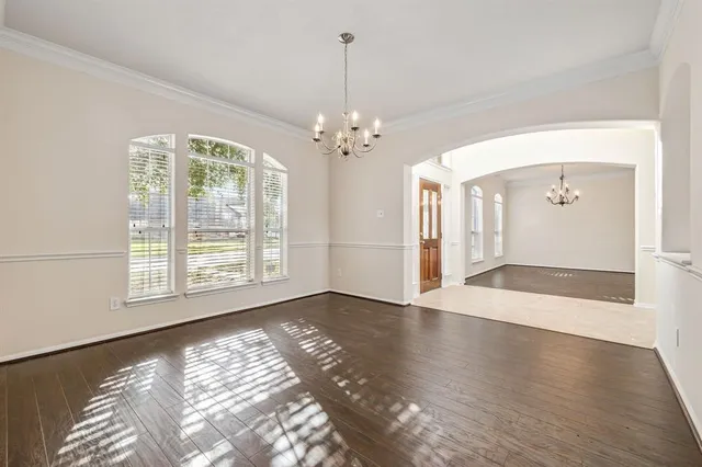 a view of an empty room with window and wooden floor