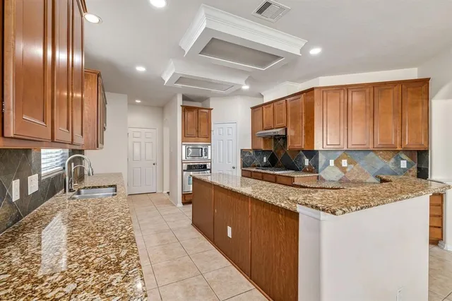 a kitchen with stainless steel appliances granite countertop a sink stove and cabinets