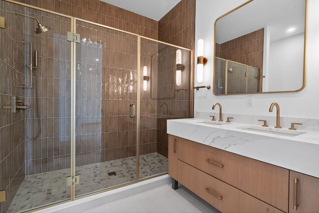 1114 Beacon Street, Unit 101 Newton, MA 02461 - Photo 13 of 29 a bathroom with a shower sink and mirror