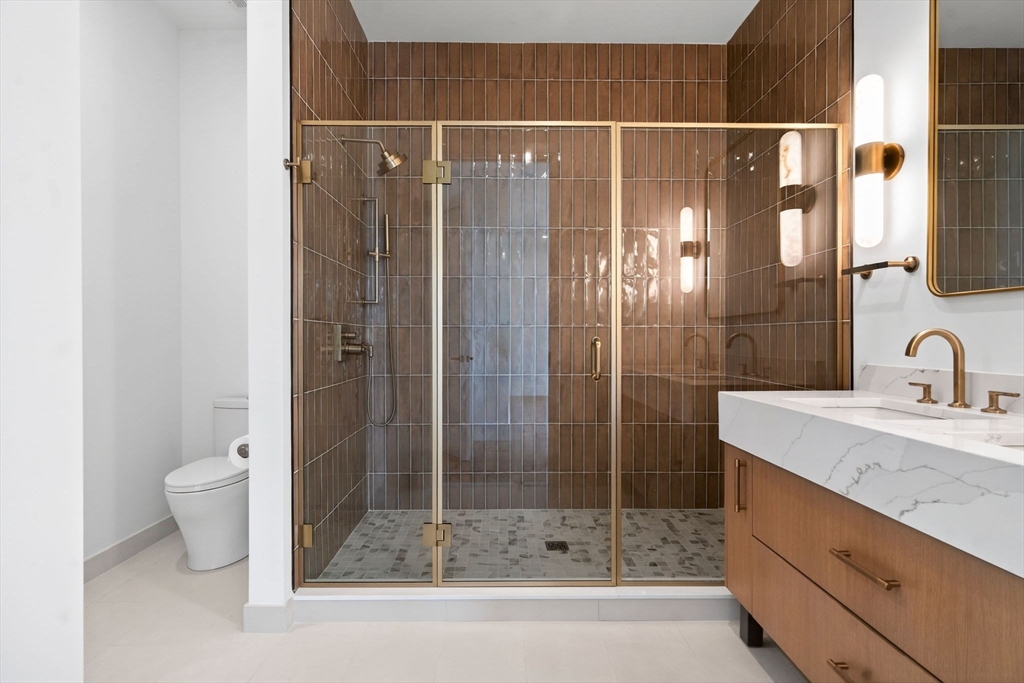 1114 Beacon Street, Unit 101 Newton, MA 02461 - Photo 16 of 29 a bathroom with a shower a sink and toilet