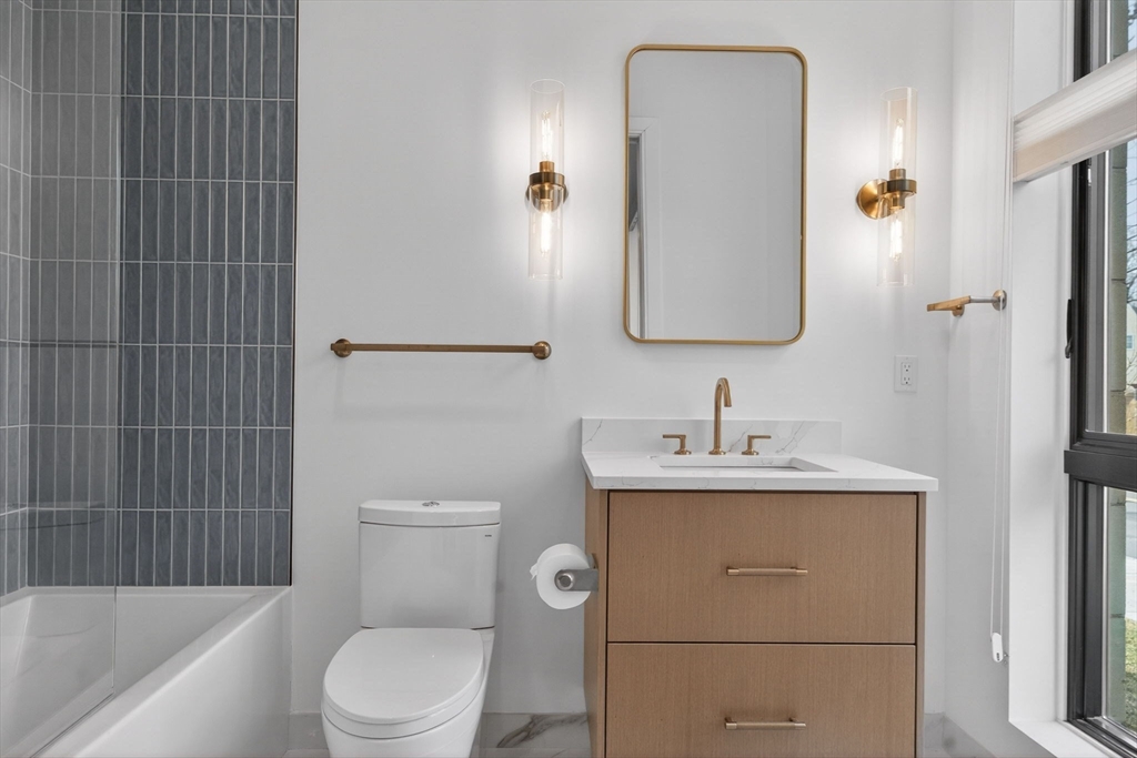 1114 Beacon Street, Unit 101 Newton, MA 02461 - Photo 18 of 29 a bathroom with a toilet a sink and a mirror