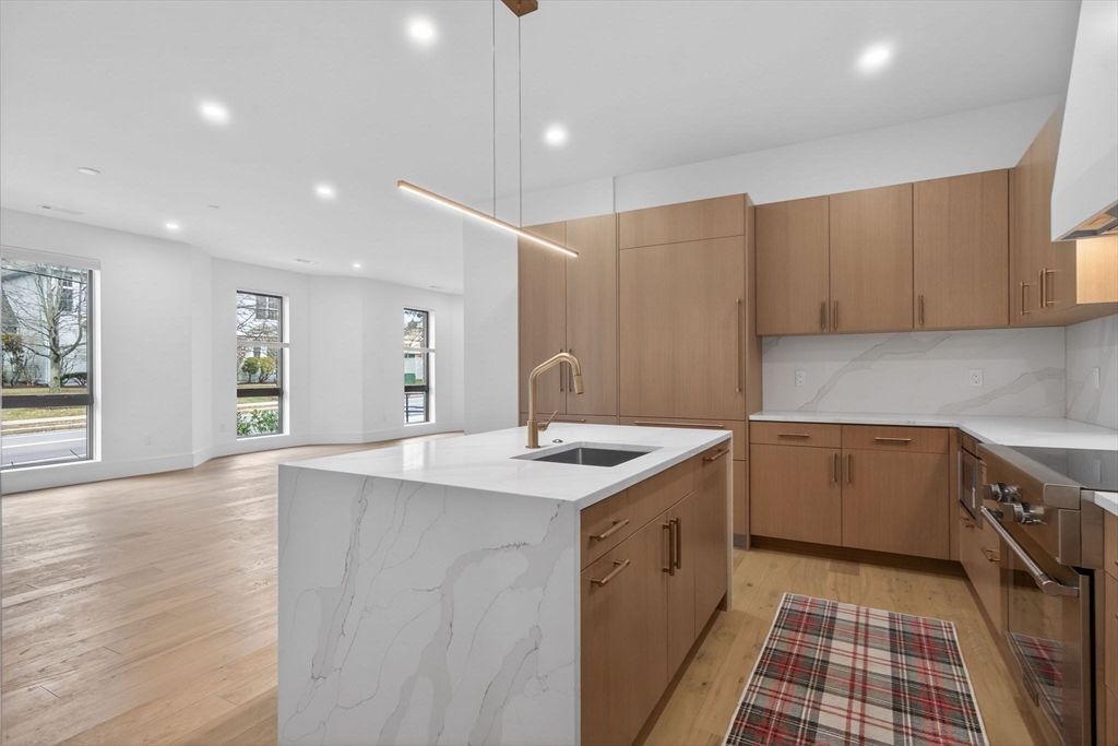 1114 Beacon Street, Unit 101 Newton, MA 02461 - Photo 5 of 29 a kitchen with a sink stove and cabinets
