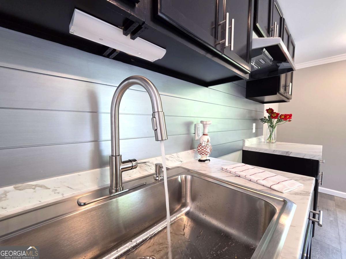 956 Donaldson Street Metter, GA 30439 - Photo 11 of 49 a kitchen with a sink a stove and cabinets