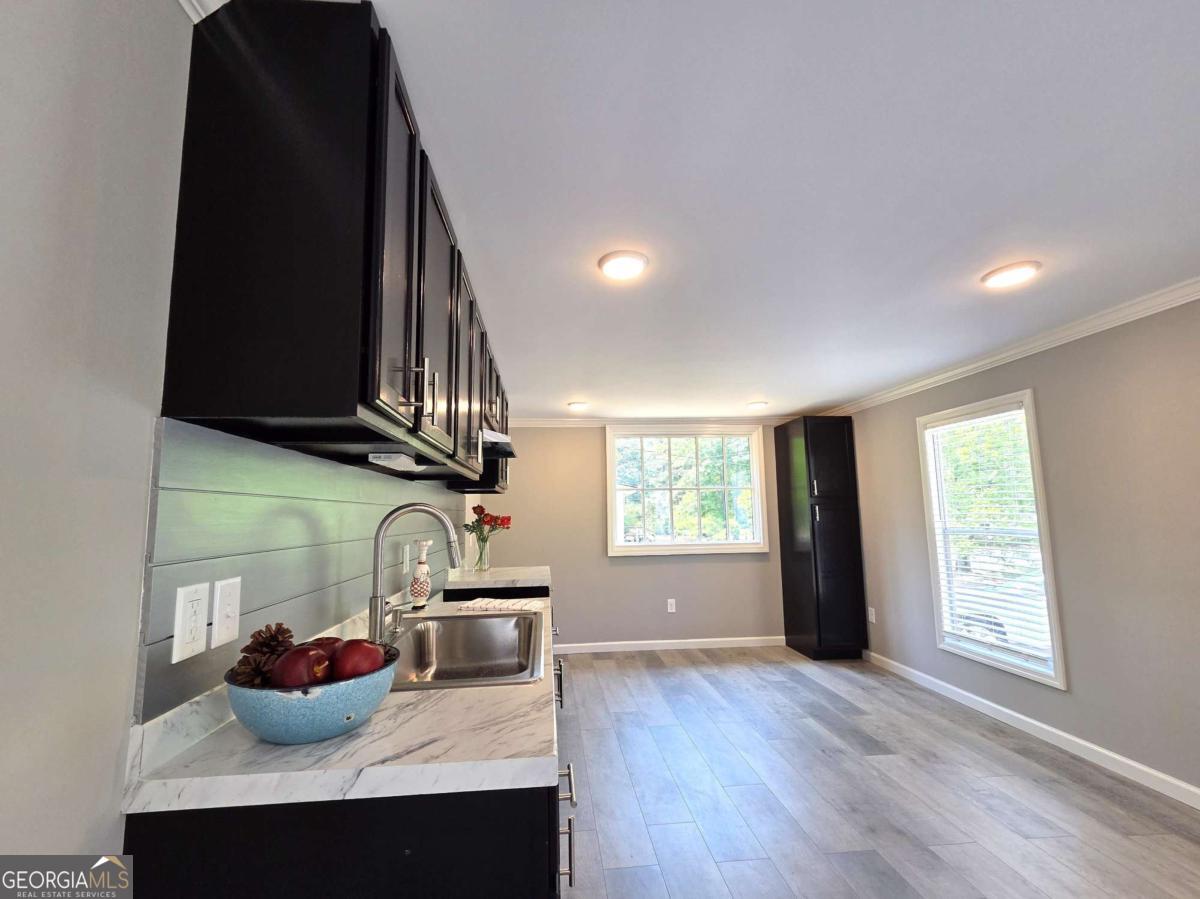 956 Donaldson Street Metter, GA 30439 - Photo 12 of 49 a kitchen with stainless steel appliances granite countertop a sink dishwasher and a stove with wooden floor