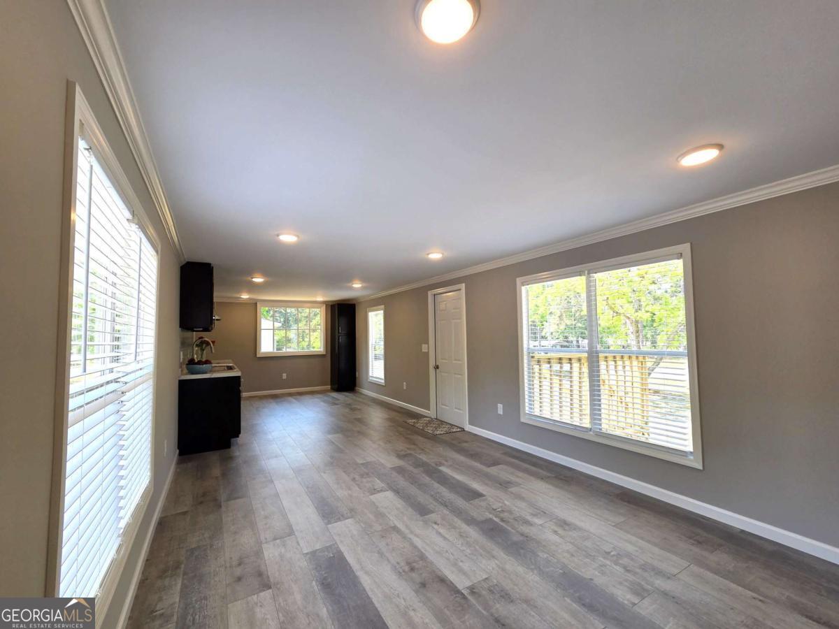 956 Donaldson Street Metter, GA 30439 - Photo 16 of 49 a view of a big room with wooden floor and windows
