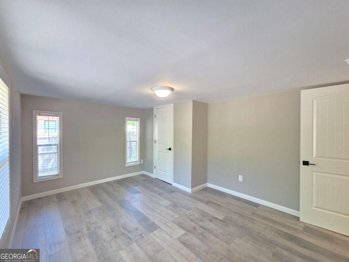 956 Donaldson Street Metter, GA 30439 - Photo 20 of 49 a view of an empty room with window and wooden floor