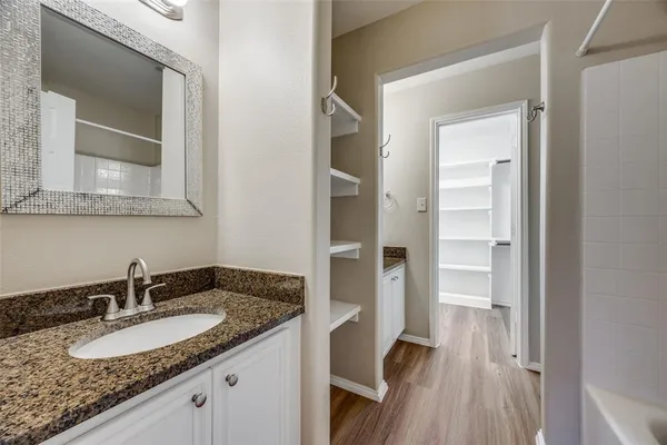 a bathroom with a granite countertop sink and a mirror