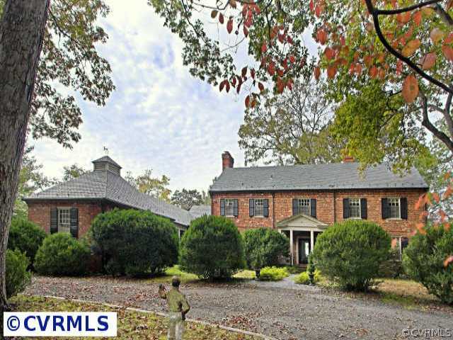 a front view of a house with a yard and tree s