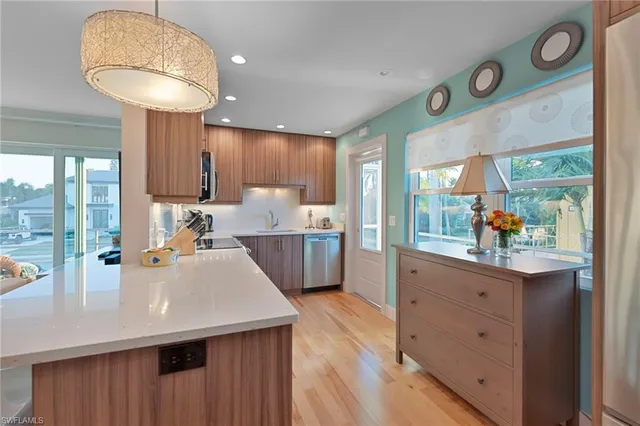 a kitchen with stainless steel appliances granite countertop a sink a stove and a refrigerator