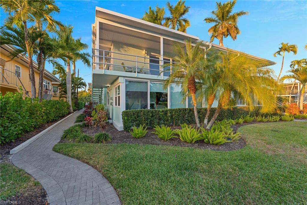 291A 8th Avenue South, Unit 291B Naples, FL 34102 - Photo 10 of 10 Rear view of house with a balcony and a lawn