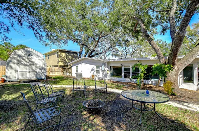 a view of a house with backyard and sitting area
