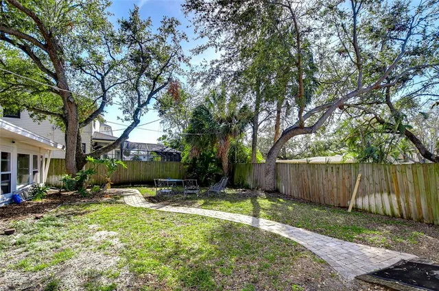 a view of a backyard with a small pool and a large tree