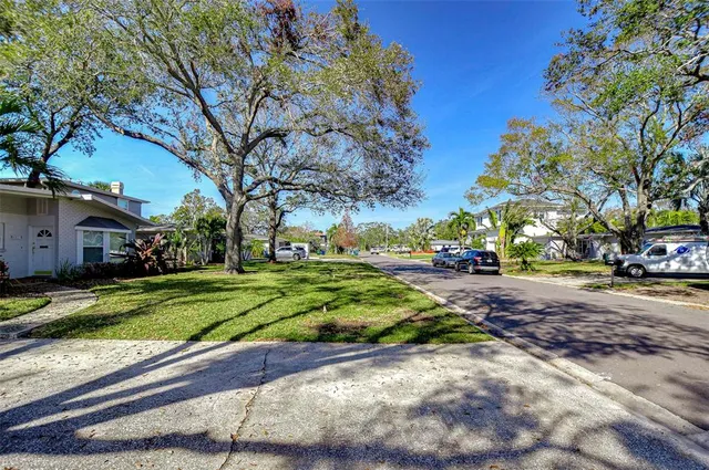 a front view of a house with a yard and trees