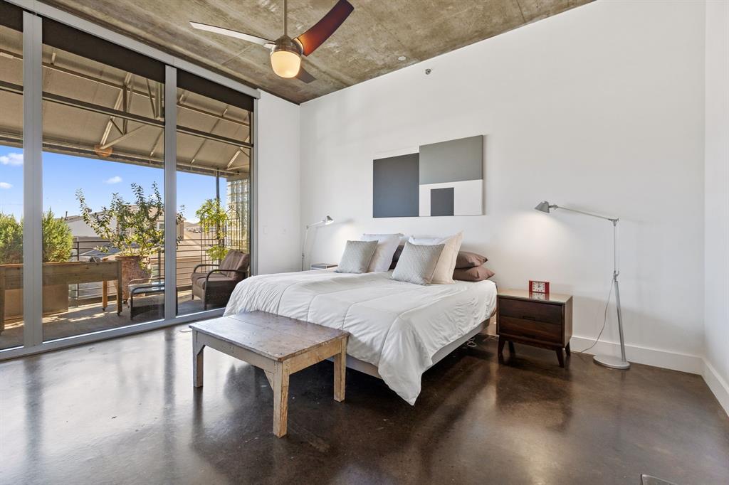 3030 Bryan Street, Unit 409 Dallas, TX 75204 - Photo 13 of 30 a bedroom with a bed and a large window with the outer view