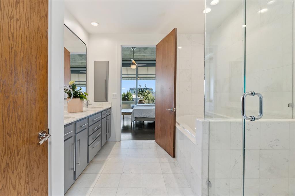 3030 Bryan Street, Unit 409 Dallas, TX 75204 - Photo 15 of 30 a bathroom with a double vanity sink a mirror and a shower